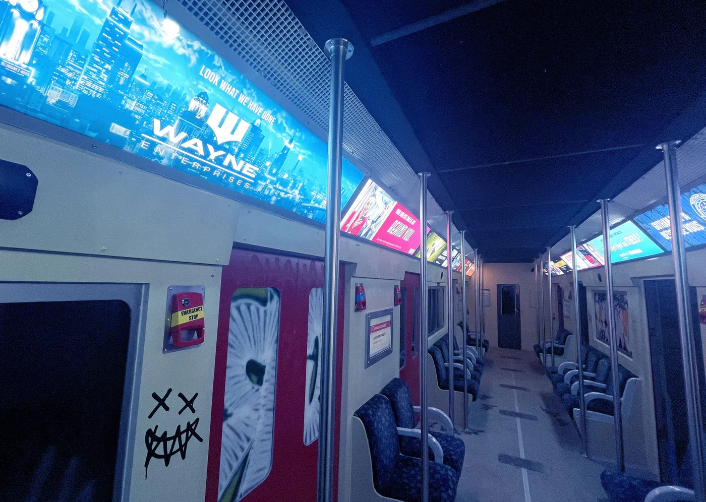 Intérieur de rame de métro thématisé, panneaux lumineux bleus Wayne Enterprises.