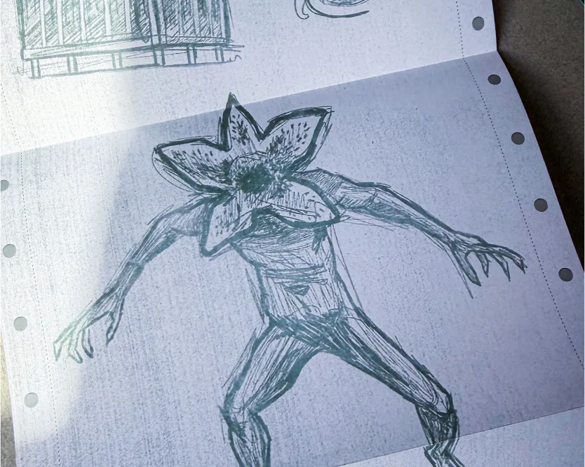 Croquis à l'encre verte d'une créature Demogorgon sur une feuille de carnet lignée.
